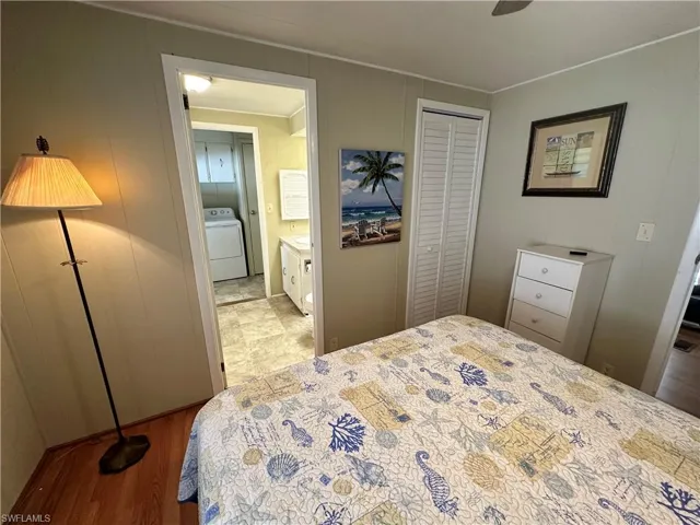 Tiled bedroom featuring washer / clothes dryer, ceiling fan, a closet, and connected bathroom