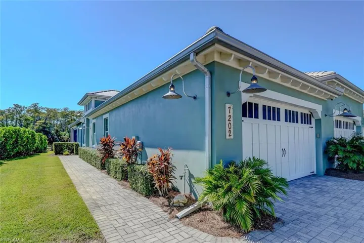 View of property exterior featuring stucco siding, a garage, and a lawn