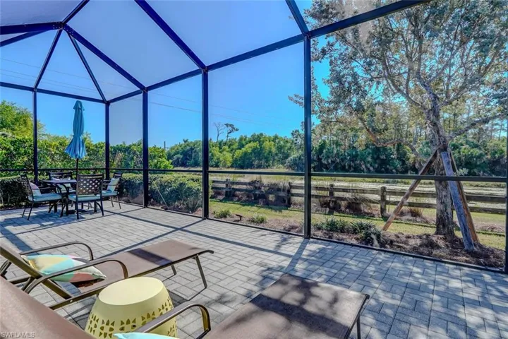 View of patio / terrace with a lanai, a sunroom, and view of wooded area