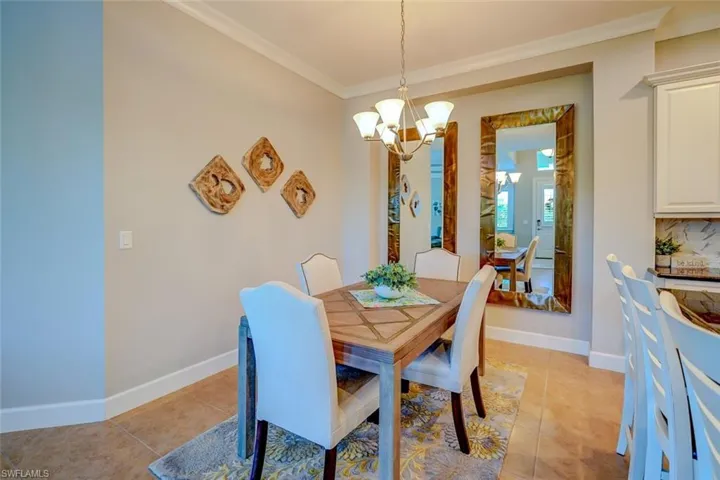 Dining room featuring a chandelier, crown molding, and light tile patterned floors