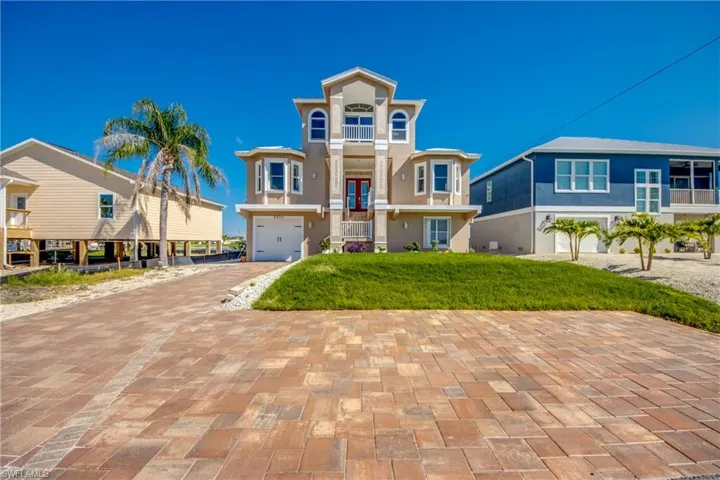 View of front of property with stucco siding, a balcony, decorative driveway, and a garage