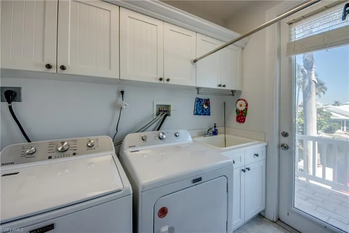 Washroom with washing machine and clothes dryer and cabinet space
