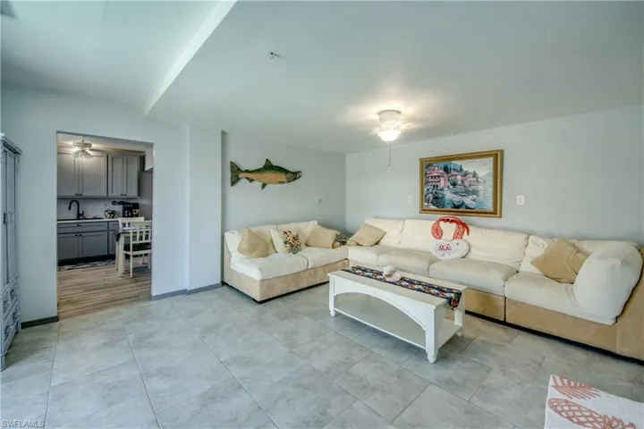 Living area with ceiling fan and light tile patterned flooring