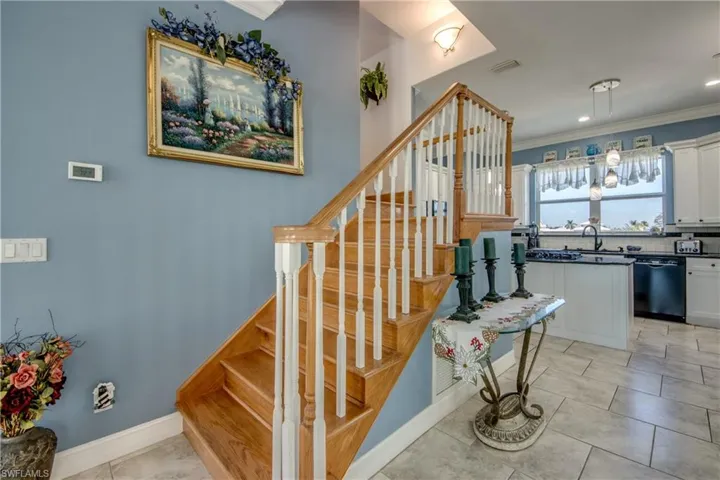 Staircase featuring crown molding, tile patterned floors, and recessed lighting