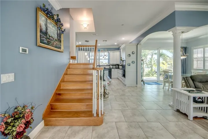 Stairs featuring ornamental molding, plenty of natural light, arched walkways, decorative columns, and recessed lighting
