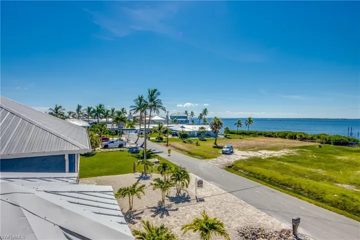 View of property's community with a water view and a lawn
