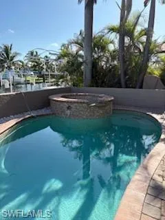 View of swimming pool featuring a pool with connected hot tub