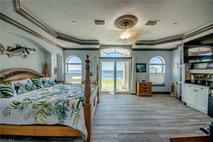 Bedroom with crown molding, light wood-style floors, access to outside, a ceiling fan, and black fridge
