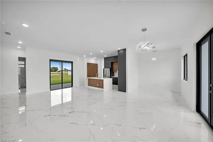 Spare room with sink, an inviting chandelier, and light tile patterned floors
