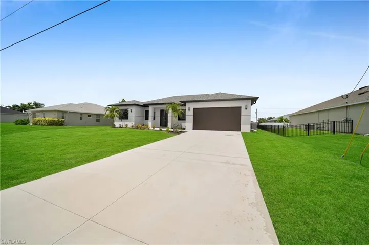 View of front of house featuring a garage and a front lawn