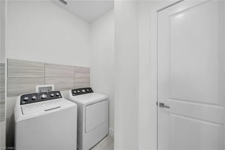 Laundry room with tile walls and washer and clothes dryer