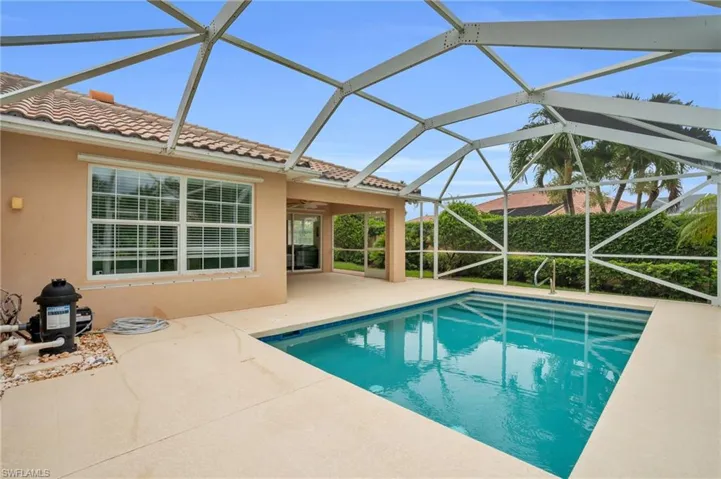 View of pool with a patio, glass enclosure, and ceiling fan