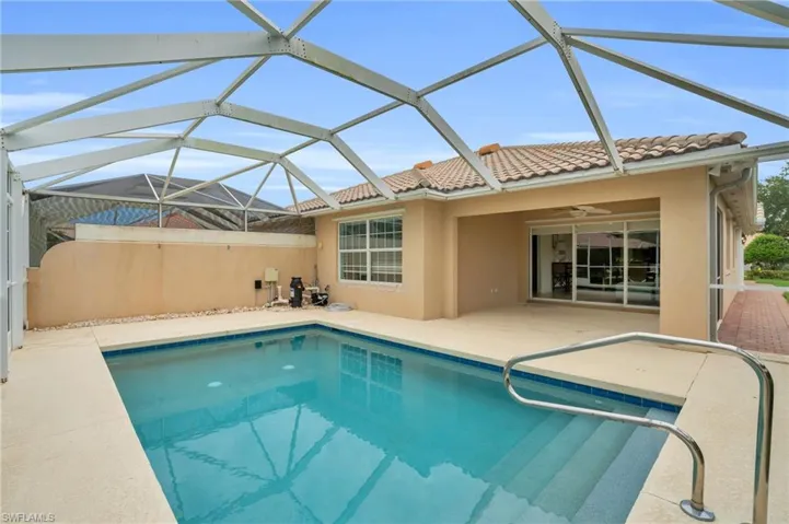 View of swimming pool featuring a patio area, a lanai, and ceiling fan