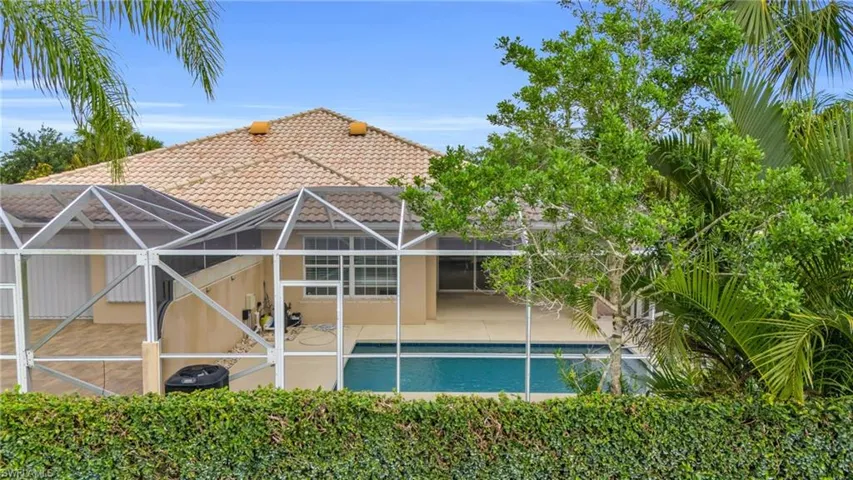 Rear view of property with a patio area and a lanai