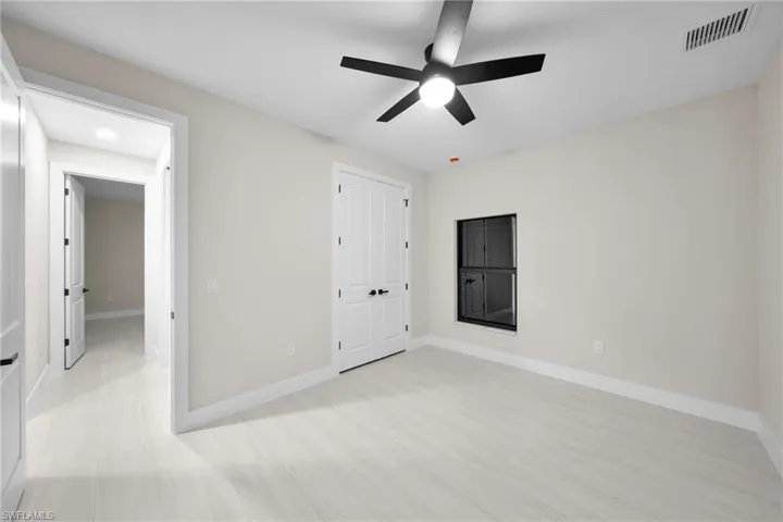 Unfurnished bedroom with ceiling fan and a closet