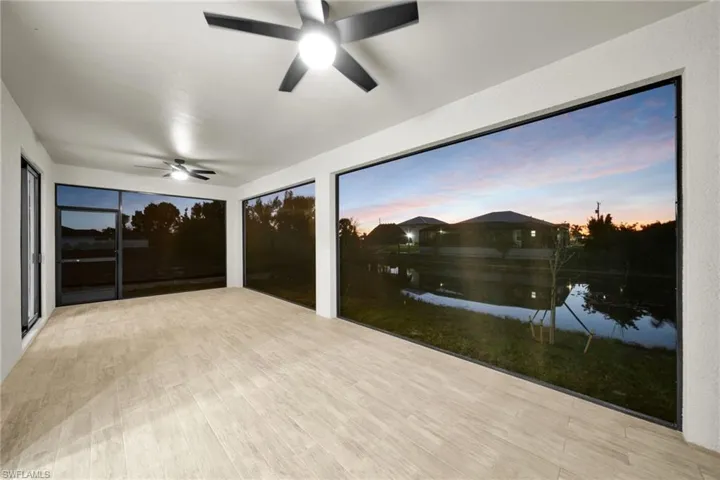Sunroom featuring a ceiling fan and a water view