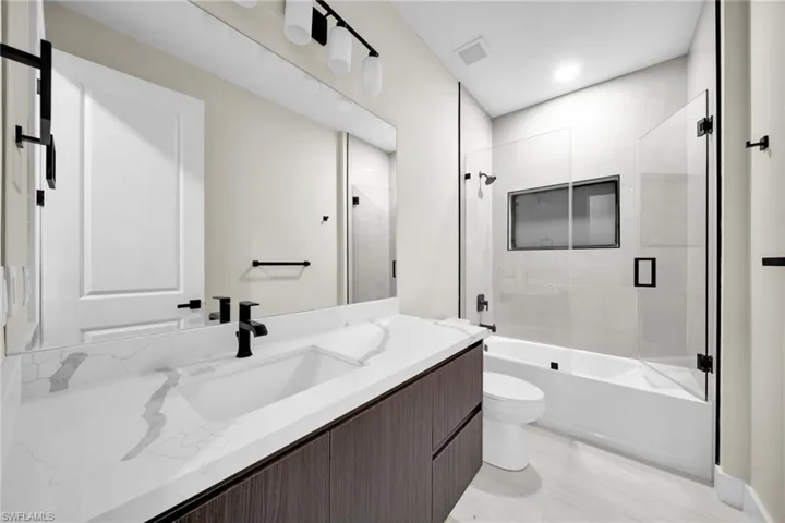 Full bath featuring vanity, enclosed tub / shower combo, and recessed lighting