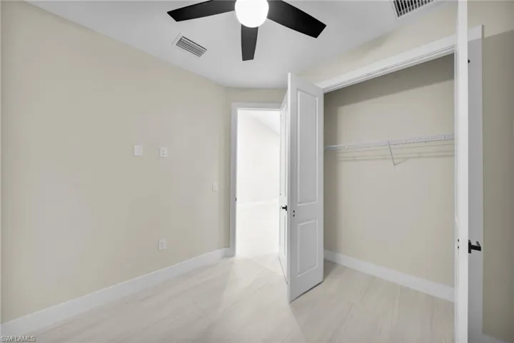 Unfurnished bedroom featuring a ceiling fan and a closet