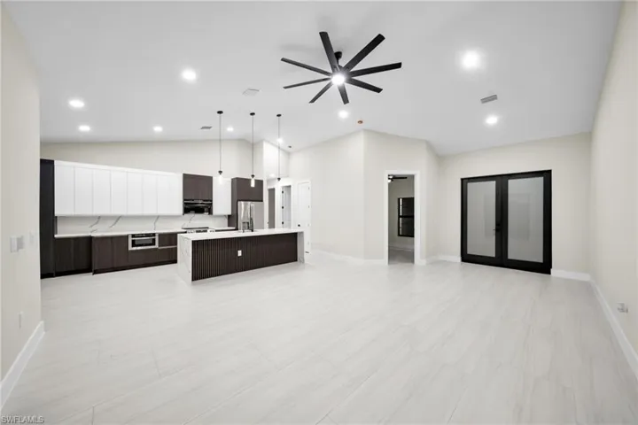 Unfurnished living room with french doors, ceiling fan, vaulted ceiling, and recessed lighting