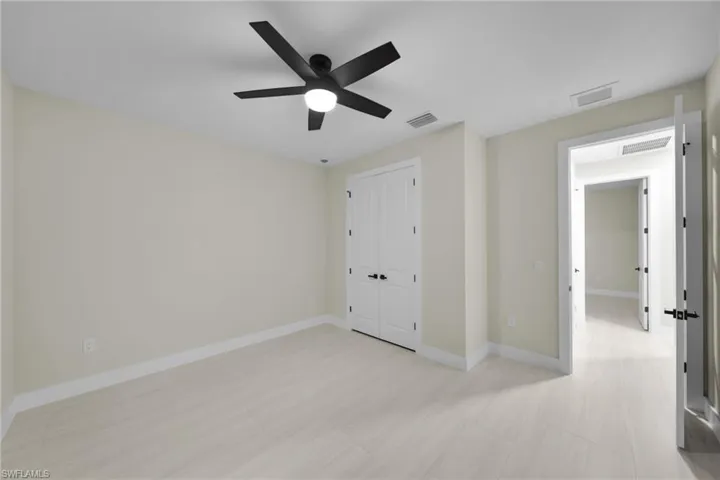 Unfurnished bedroom with a ceiling fan and a closet