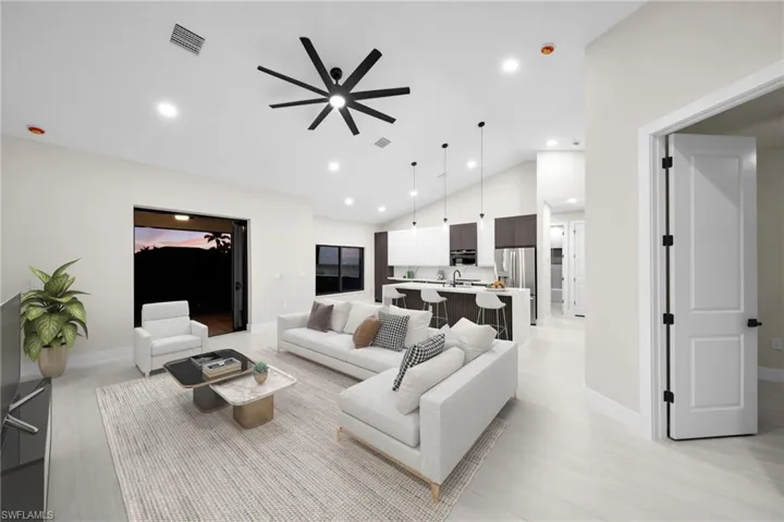 Living area featuring a ceiling fan, vaulted ceiling, and recessed lighting