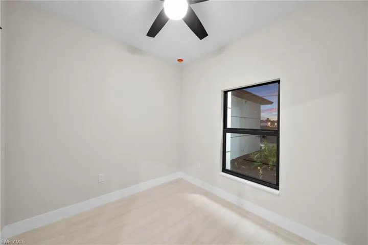 Empty room with a ceiling fan and wood finished floors