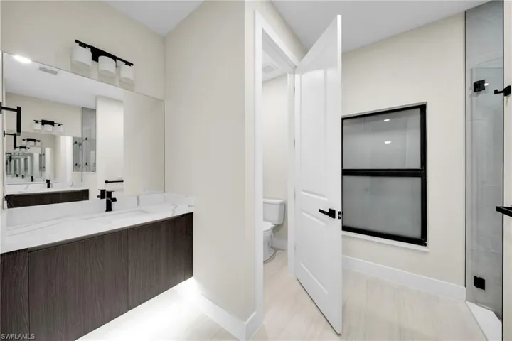 Full bath featuring a shower with shower door and vanity