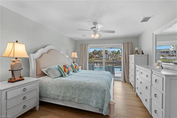Bedroom featuring multiple windows, access to outside, light hardwood / wood-style floors, and ceiling fan
