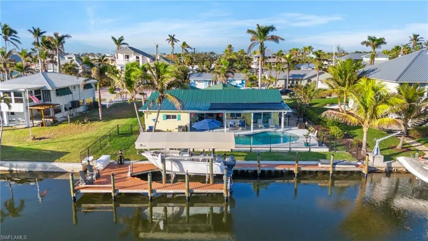 Rear view of house with a lawn and a water view