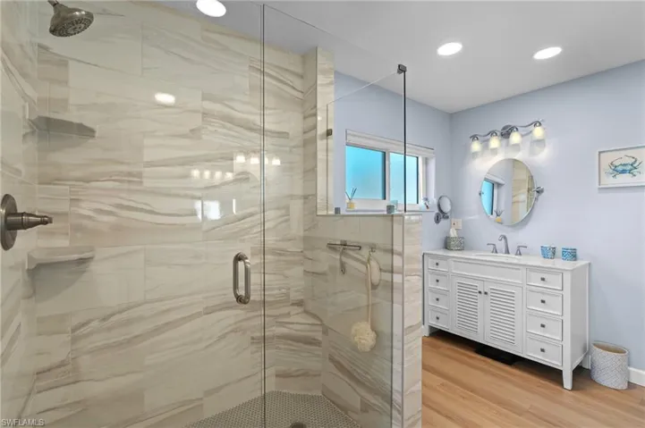 Bathroom featuring vanity, hardwood / wood-style floors, and a shower with shower door