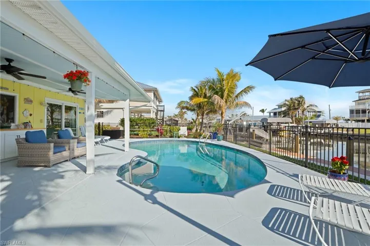 View of pool with an outdoor hangout area, a patio area, ceiling fan, and a water view