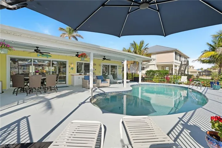 View of swimming pool with ceiling fan, outdoor lounge area, and a patio