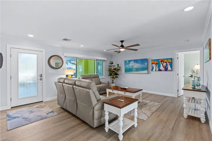 Living room with crown molding and light hardwood / wood-style flooring