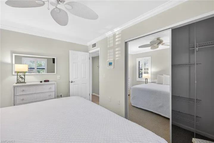 Carpeted bedroom with crown molding and ceiling fan