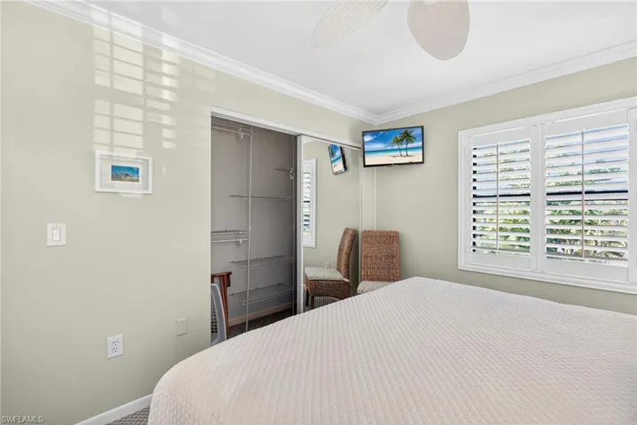 Bedroom featuring a closet, ornamental molding, ceiling fan, and carpet flooring