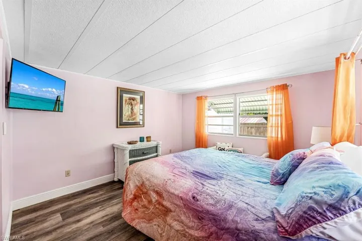 Bedroom featuring a textured ceiling and dark wood-type flooring