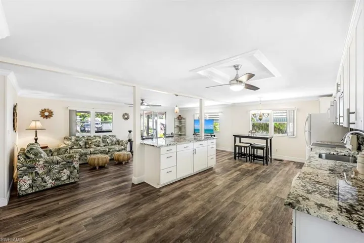 Kitchen with white cabinets, a healthy amount of sunlight, sink, and ceiling fan