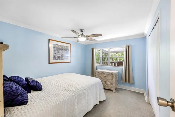 Bedroom featuring crown molding, ceiling fan, and light carpet