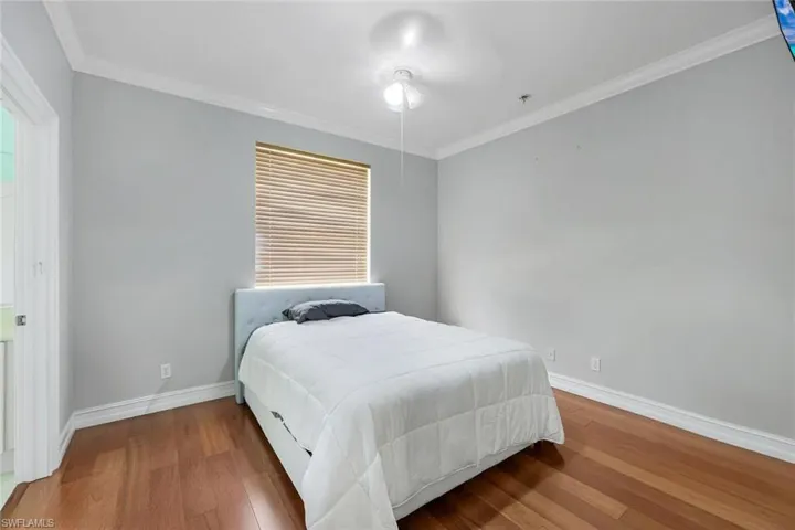 Bedroom featuring crown molding, wood finished floors, and ceiling fan