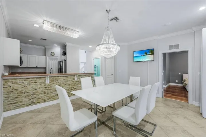 Dining room featuring ornamental molding, recessed lighting, a chandelier, and light tile patterned floors