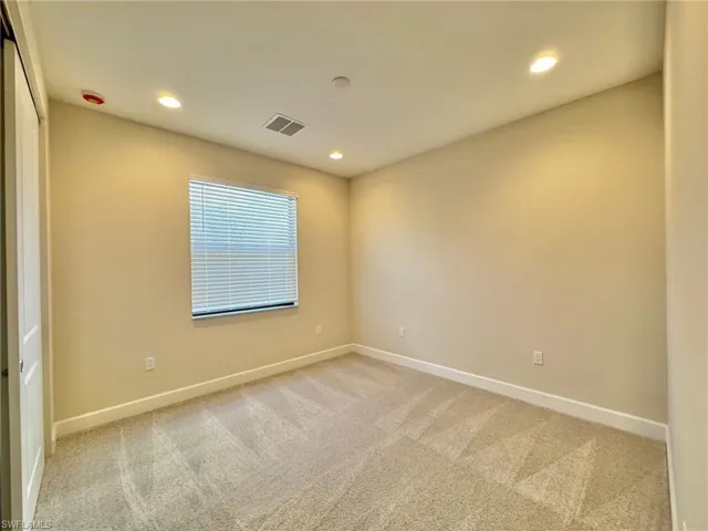 Spare room with light colored carpet and recessed lighting