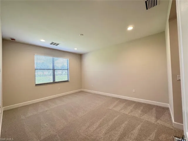 Spare room featuring recessed lighting and light colored carpet