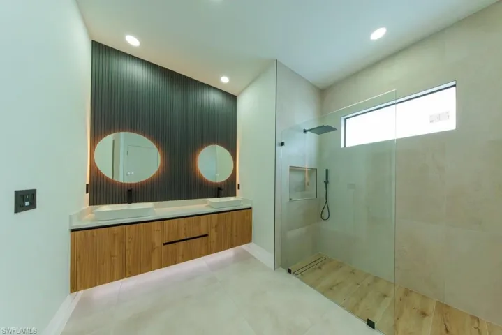 Full bath featuring walk in shower, double vanity, and recessed lighting