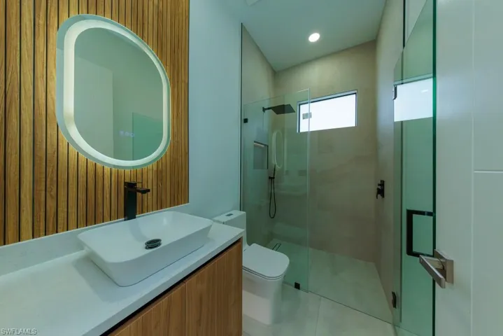 Full bath with a shower stall, vanity, and tile patterned flooring
