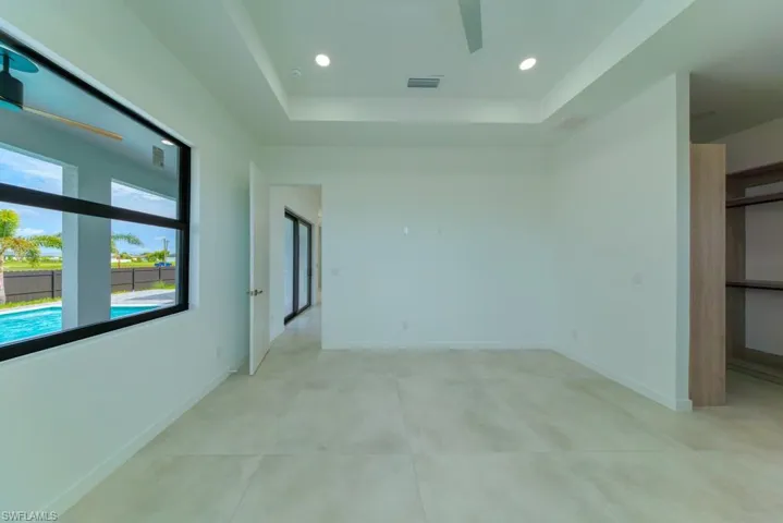 Unfurnished bedroom featuring a raised ceiling and recessed lighting