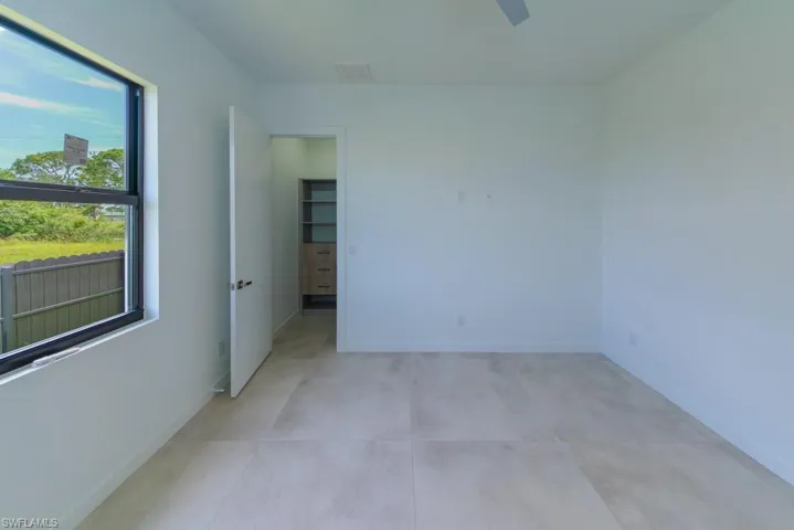 Empty room featuring light tile patterned floors and ceiling fan