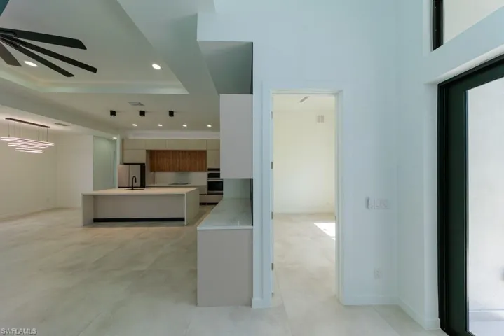 Kitchen featuring modern cabinets, light countertops, stainless steel appliances, a tray ceiling, and ceiling fan