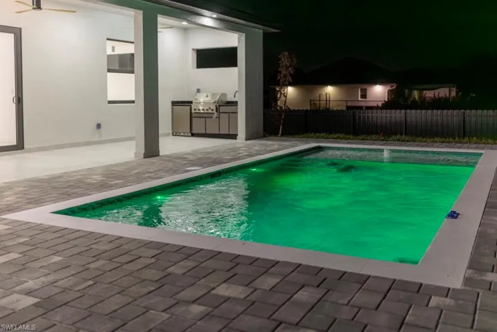 View of swimming pool featuring area for grilling and a patio