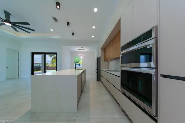 Kitchen with modern cabinets, double oven, white cabinets, and recessed lighting