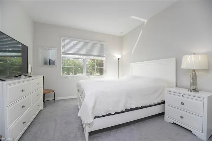 Bedroom with light colored carpet and baseboards